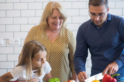 A family happily preparing vegetables together in a modern kitchen.