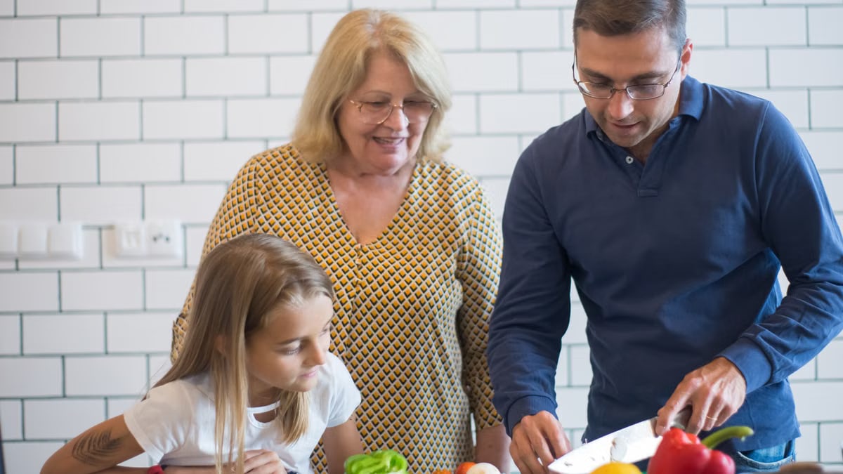 A family happily preparing vegetables together in a modern kitchen.